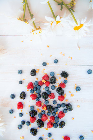 Ripe blackberries, blueberries, raspberries. Top view on white wooden backgroundの写真素材