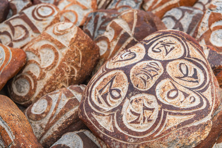 Pebbles from sacred Lake Manasarovar with hieroglyphs and main Buddhist mantraの写真素材