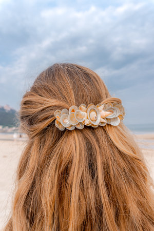 Beautiful hairpin hairgrip made of small clams on the red hair of a model on the beach, diy handmade conceptの写真素材