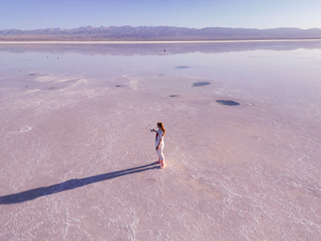Girl is using a drone at Chaka Salt Lake in Qinghaiの写真素材