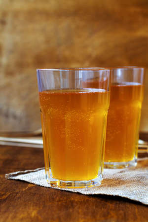 Homemade bread kvass on brown background. Summer soft drink. Glass of beer with sackcloth on a...