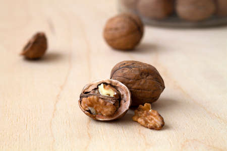 close-up walnuts in shells on a wooden table and in a glass jar. brown nuts on a background. copy space.の写真素材