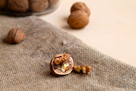dried walnut on the sackcloth. close-up peeled walnuts in shells on a wooden table and in a glass...
