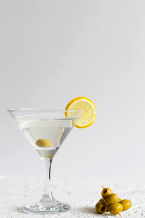 martini with lemon. Martini glass with cocktail and olives on white background. Cocktail Margarita with lime and lemon on the table. copy space. alcohol drinks. verticalの写真素材