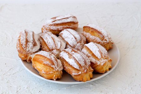 homemade vanilla eclairs on a plate on a white table. copy space. Traditional french tasty dessert...