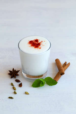 Lassi drink with red pepper and fresh green mint on white background. dessert, yogurt or milk with...