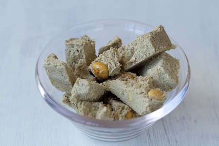 close-up cutting halwa from sunflower seeds with peanut in the glass bowl. national traditional...