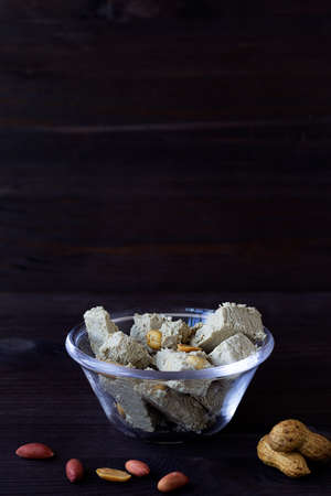 pieces of halwa from sunflower seeds with peanut in the glass bowl. national traditional sweetness...