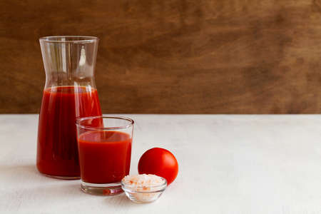 tomato juice in a glass.Tomato juice with pink salt. Healthy drink with tomato juice in a glass isolated on a white background with copy spaceの写真素材