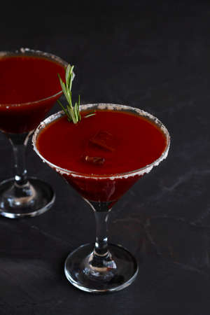 Bloody Mary cocktail. Alcoholic drink with vodka and tomato juice in a glass isolated on a black background. vampiro cocktail with pepper on table. copy space. verticalの写真素材