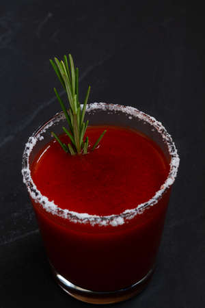Close-up Tomato juice with celery, spices, salt and ice in glass with copy space. Bloody Mary...