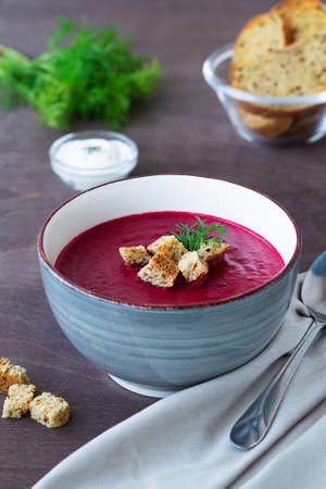 gray bowl of soup.vegetable soup with greens and croutons. bowl of Beetroot cream soup with bread...
