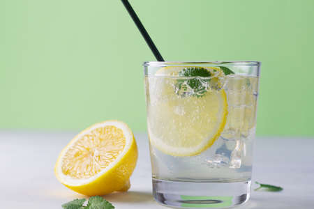 lemonade with lemon.Summer refreshing cocktail with lime and mint on white wooden background. Fresh summertime iced drink with yellow citrus and green leaves in glasses. copy spaceの写真素材