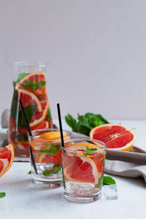 two glasses of Cocktail grapefruit with fruits. fresh Grapefruit juice with green mint on beige...