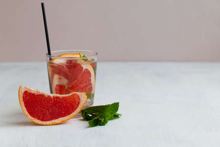 fresh grapefruit juice and fruit.Refreshing summer drinks on the white table. glass of Cocktail grapefruit. Grapefruit lemonade with green mint on beige background. copyspace.の写真素材