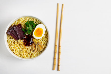 noodles with chopsticks.Japanese ramen noodles with chicken, boiled egg, mushrooms, spring onions...
