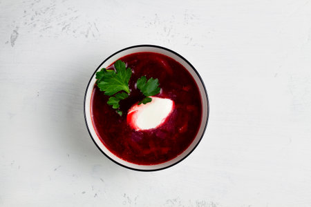 Beetroot soup with sour cream in a bowl on a white backgroundの写真素材