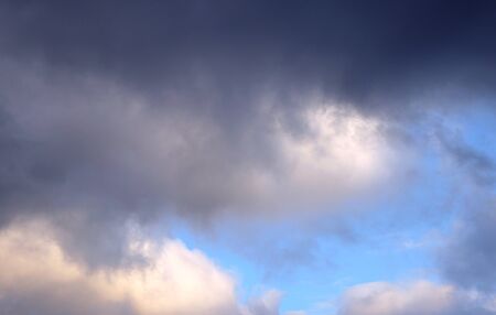 Dark clouds on the blue sky. The weather is going bad, it's going to rainの写真素材