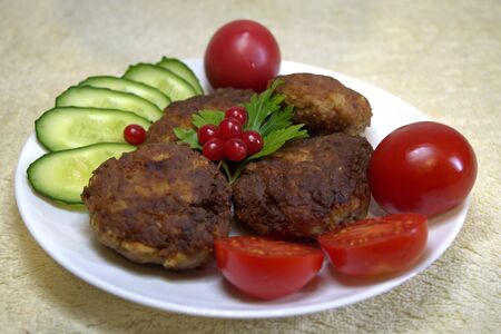 Homemade meatballs delicious and fragrant from ground beef and pork. With fresh cucumber, tomato and herbs. On a white plate.の写真素材