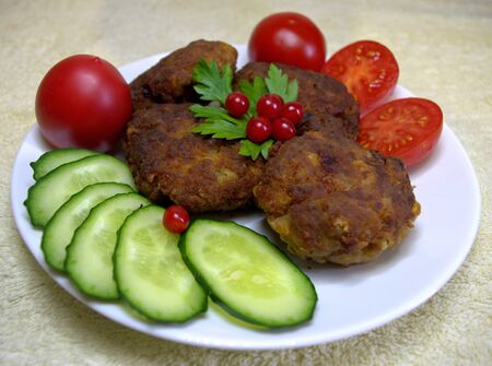 Homemade meatballs delicious and fragrant from ground beef and pork. With fresh cucumber, tomato and herbs. On a white plate.の写真素材