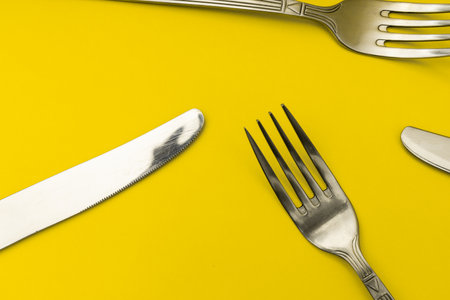 Cutlery lying on a yellow background, minimalismの写真素材