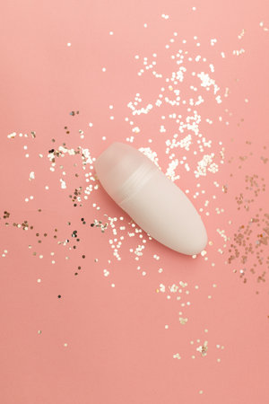 Roller deodorant in a white bottle on a pink backgroundの写真素材