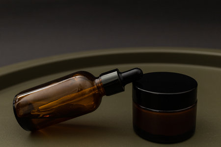 Jars and bottles of cosmetics on a dark background, the minimalism of the beauty industryの写真素材