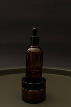 Jars and bottles of cosmetics on a dark background, the minimalism of the beauty industryの写真素材
