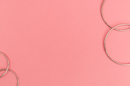 Silver costume jewelry on a delicate pink background, advertising shoot