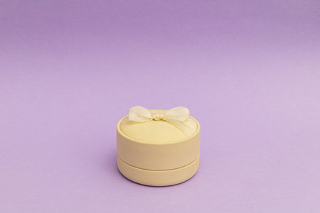 White ring box on a bright purple background