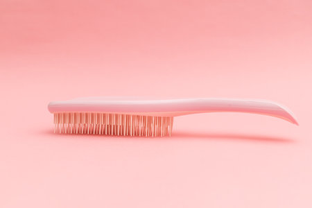 Plastic hairbrush with pink background