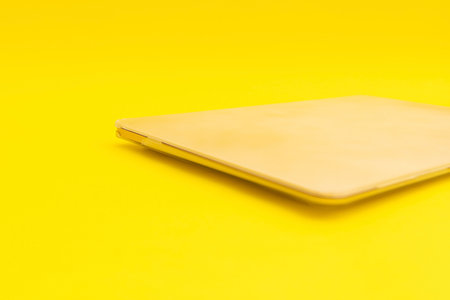 Laptop lies on a golden background