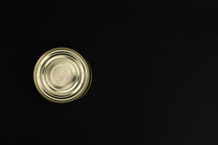 Canned food in a tin on a black background