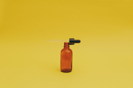 Serum bottle on yellow backgroundの写真素材