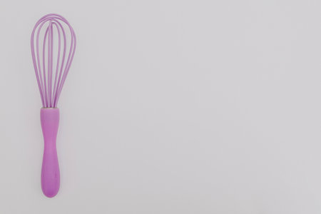 Purple whisk for the kitchen on a white backgroundの写真素材