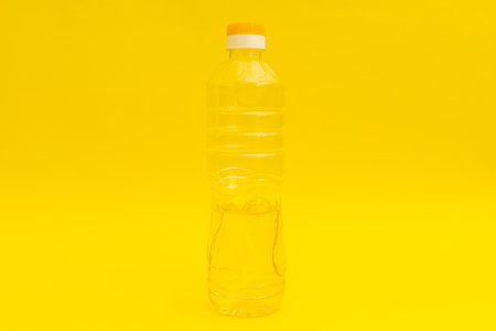 Yellow pasta tongs on yellow background, monochromeの写真素材