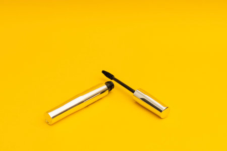 Mascara in silver package with yellow backgroundの写真素材