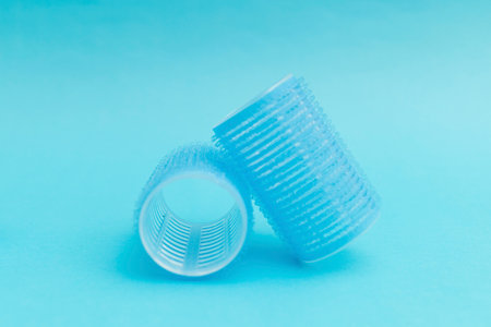 Blue hair curlers on a blue backgroundの写真素材