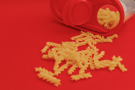 Pasta scattered on a red backgroundの写真素材