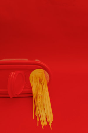 Raw pasta on red backgroundの写真素材