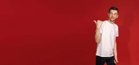 Banner with a young man in a white T-shirt pointing a finger in the direction, copyspace