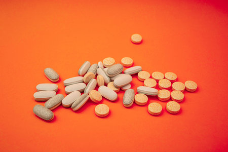 Pills on a bright orange background, treatment and health theme