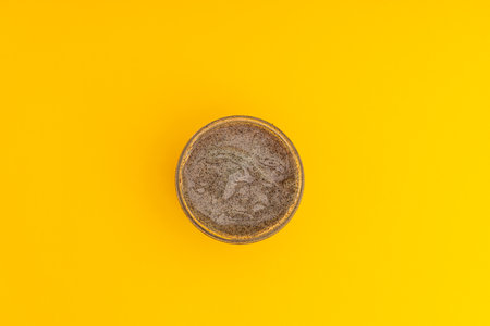 Body and head scrub in a jar on a yellow background