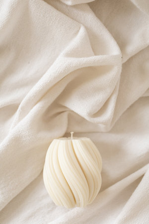 The wax wicker candle lies on the clothの写真素材