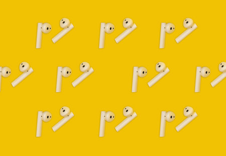 Collage with white wireless headphones on a yellow backgroundの写真素材