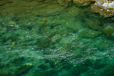 A stunning view of the clear, green waters of a river in Aurlandsdalen, Norway. The image showcases...