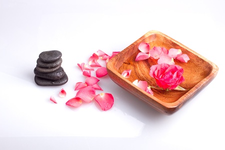 Massage stone with rose petal on a white backgroundの写真素材