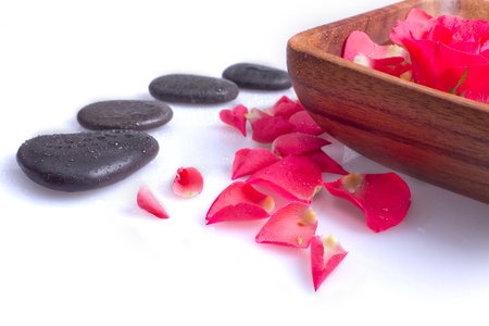 Massage stone with rose petal on a white backgroundの写真素材