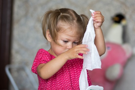 a little girl pulls out napkins to wipeの写真素材