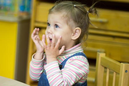 little girl playing and studying on lessons in kindergardenの写真素材
